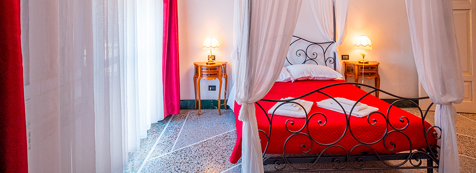 Camera con letto a baldacchino rosso